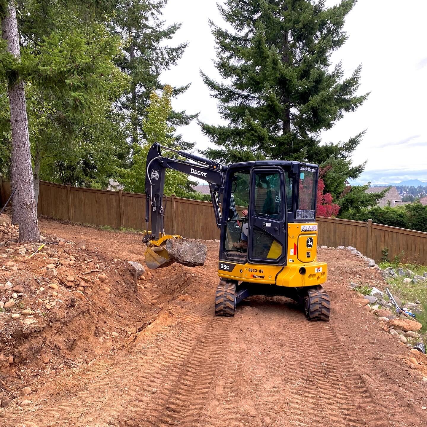 Excavator grading backyard Vancouver Island