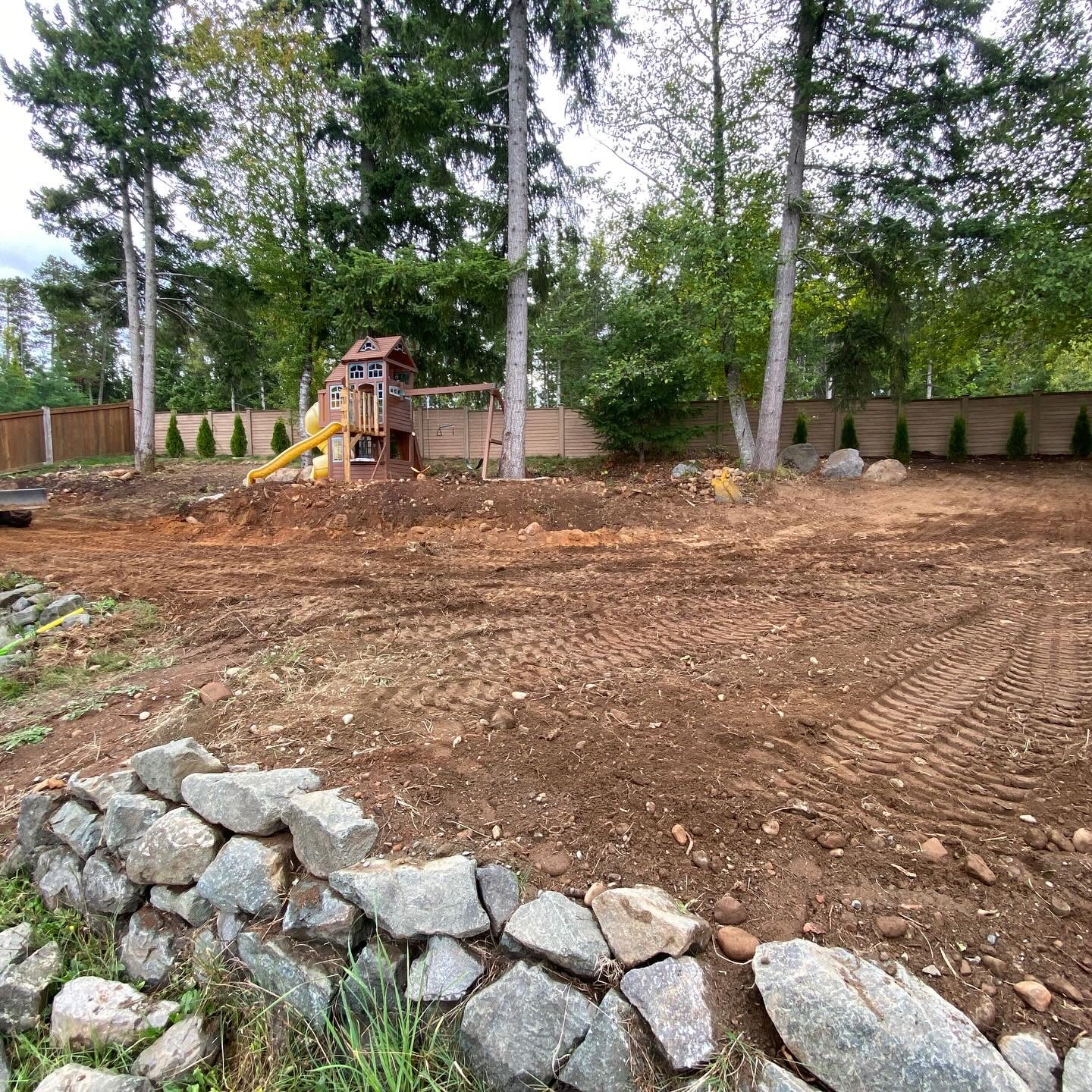 Backyard grading with boulder wall Vancouver Island